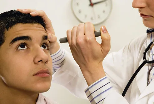 Dokter memeriksa mata pasien pria muda