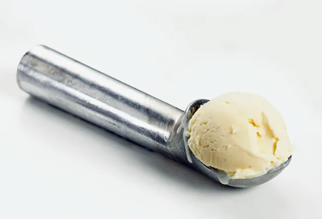 Metal scoop with vanilla ice cream