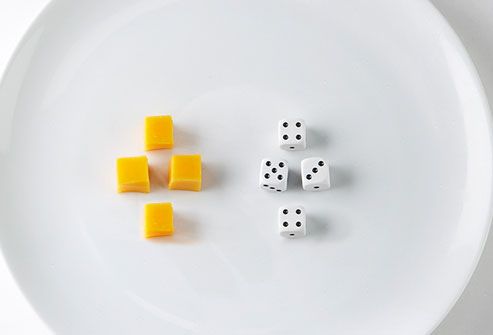 Cubes of cheese and dice on plate