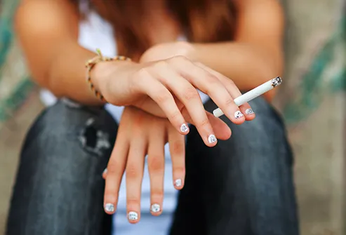 teen holding lit cigarette