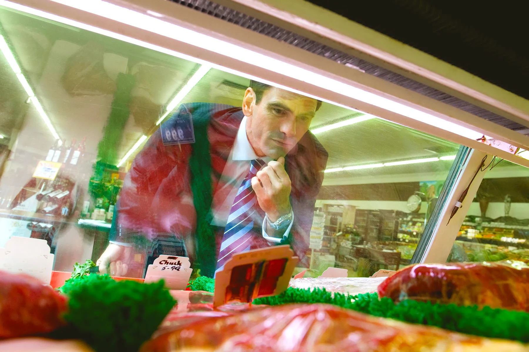 photo of man at meat counter in supermarket