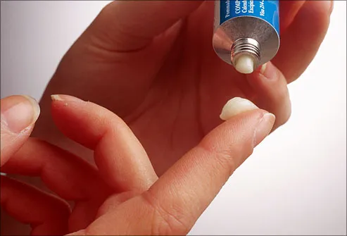 Woman squeezing ointment onto finger