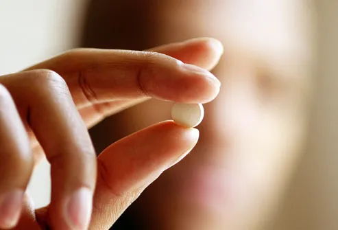 Extreme close up of hand holding pill