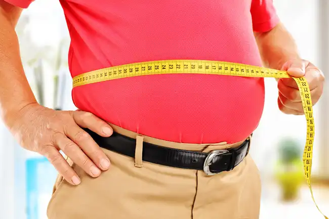 man measuring belly fat