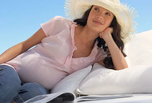 Pregnant young woman wearing sun hat