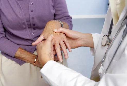 examining hand for signs of rheumatoid arthritis