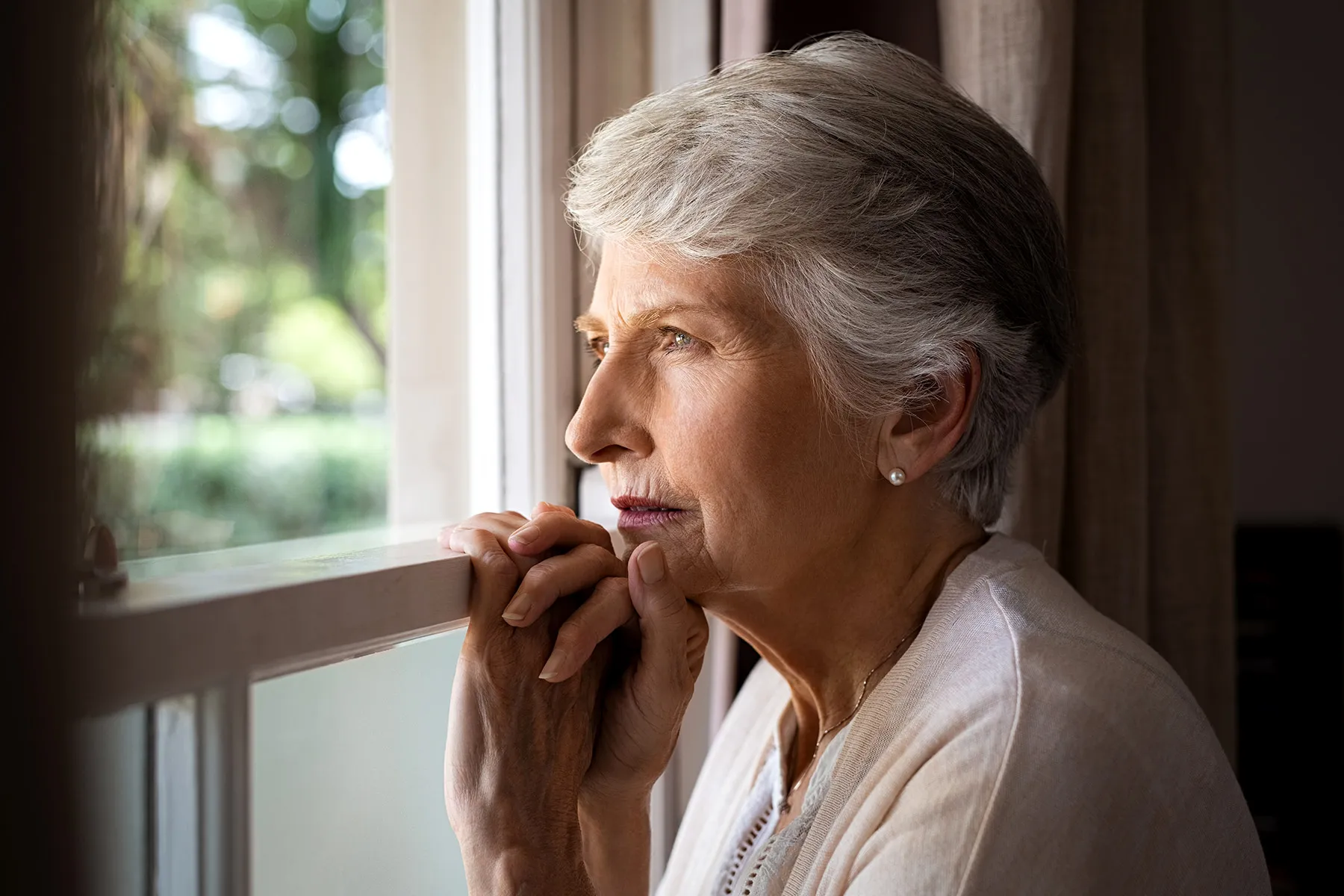 photo of mature woman looking out window