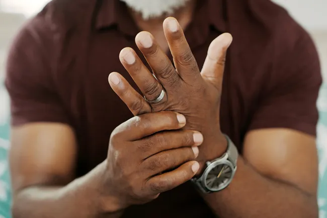 photo of senior man rubbing arthritic