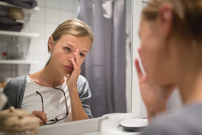 woman exhausted at mirror