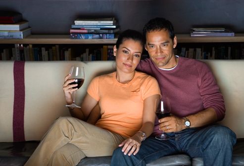Couple watching television and drinking red wine