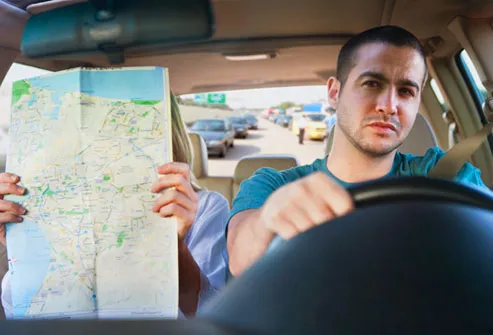 Man driving while his wife navigates with a map