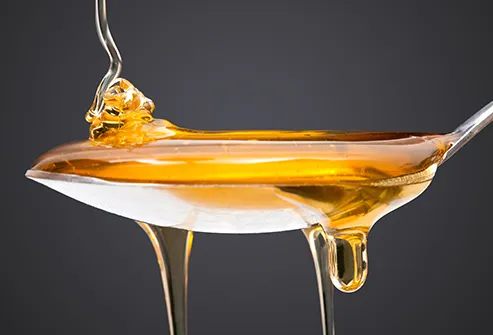 drizzling honey onto spoon