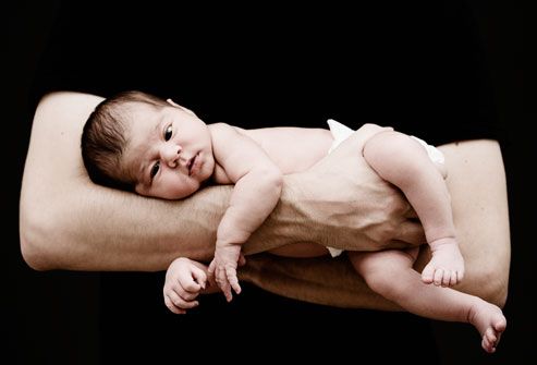 Father Holding Newborn Baby In Arms