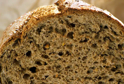 Cut rustic loaf of whole wheat bread
