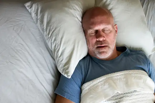 man snoring in bed