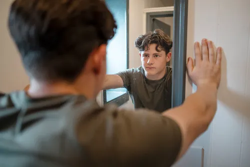 photo of boy looking in mirror