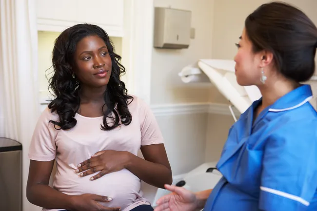 photo of doctor talking to pregnant woman