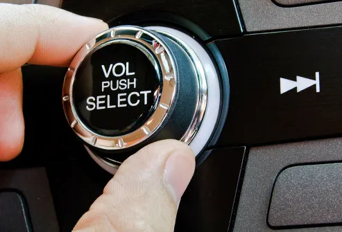 man turning up stereo volume in car