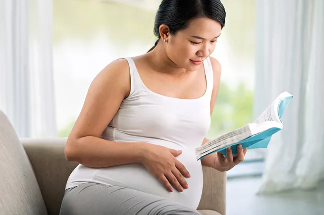 photo of pregnant woman reading book