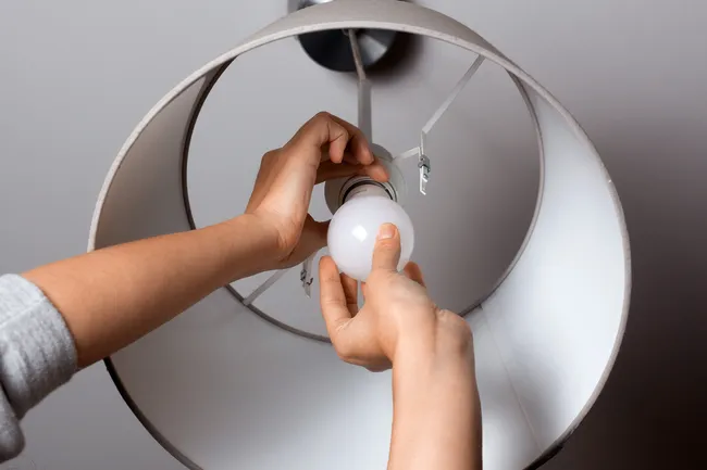 photo of person changing light bulb