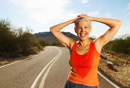 Smiling female jogger taking a breather roadside