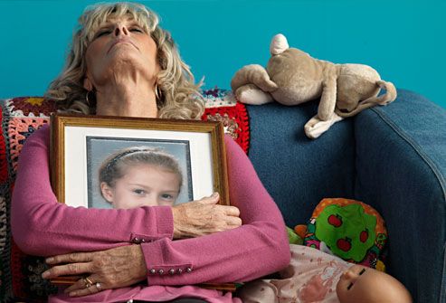 Grieving woman clutching photo of deceased child