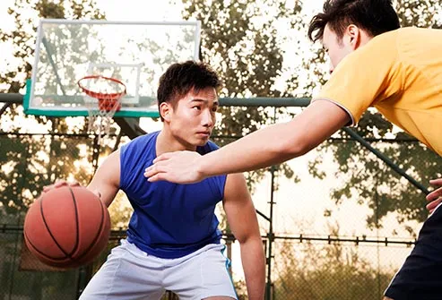 two young men playing basketball