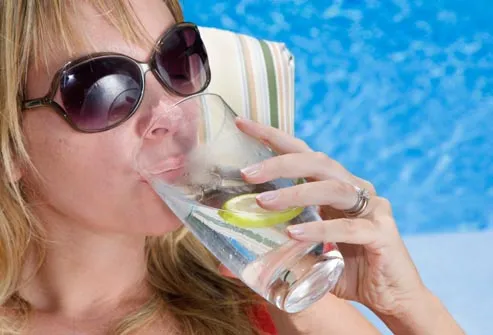 woman drinking water poolside