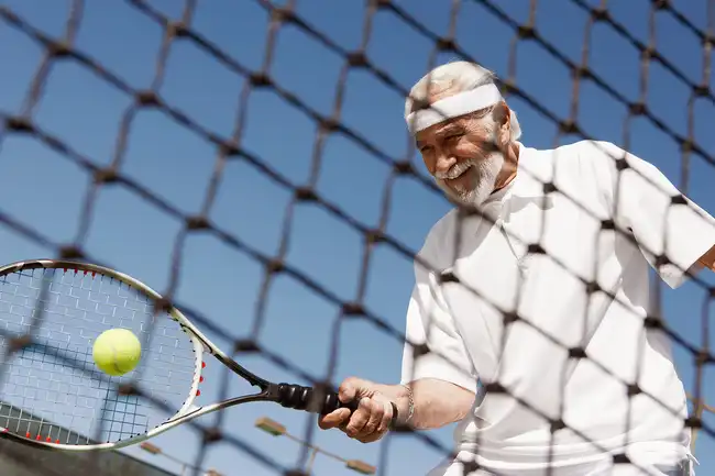 mature man playing tennis