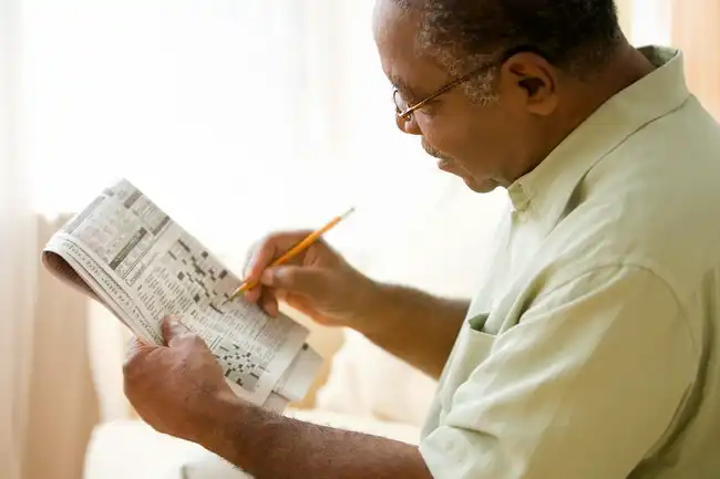 mature man working crossword