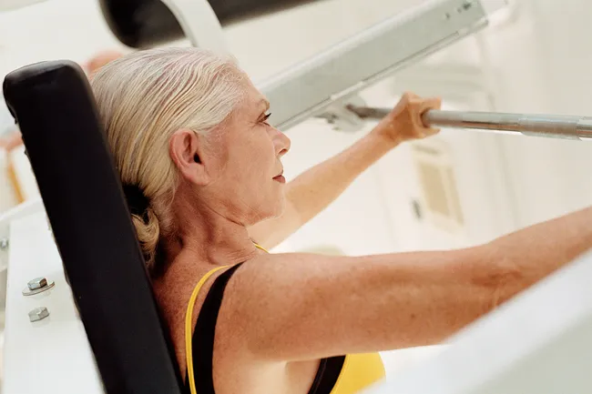 photo of mature woman bench pressing