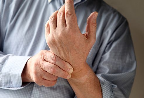 senior man massaging numb hand