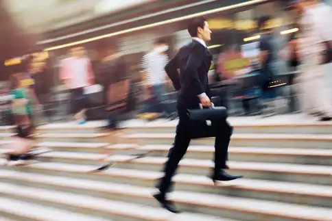 photo of businessman running up steps