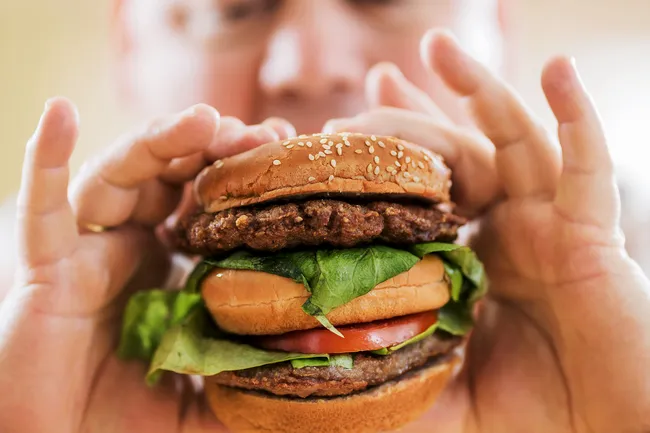 photo of man holding hamburger