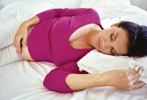 pregnant woman sleeping on bed