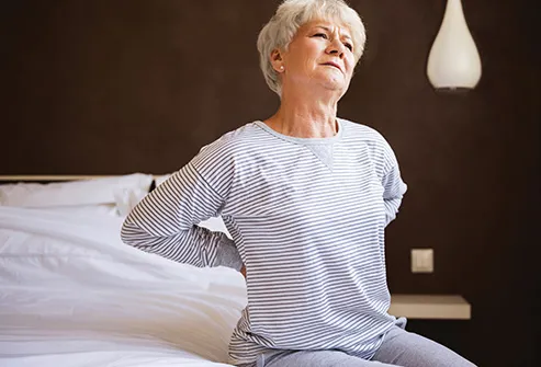 senior woman with back pain on bed