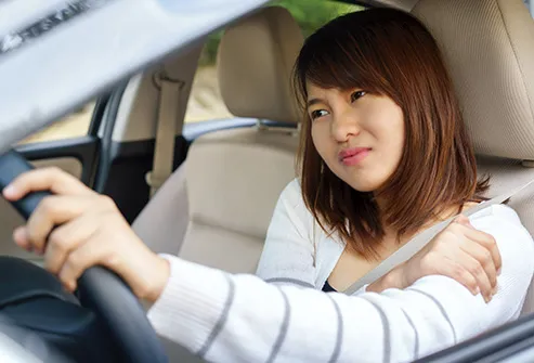 woman driving car with sore shoulder