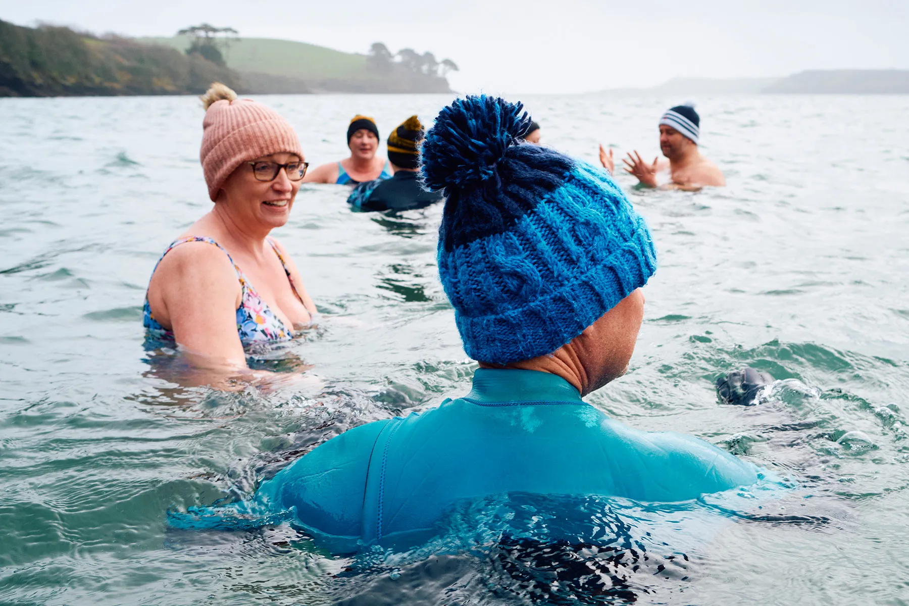 photo of mature adults swimming in cold water