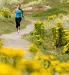 jogger running among flowering plants