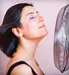 Woman standing with fan in face