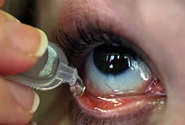 person using eye drops