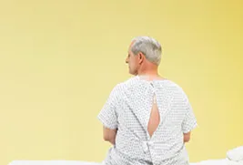 male patient sitting on exam table
