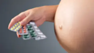 pregnant belly, pills in hand