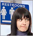 woman standing in front of restroom sign