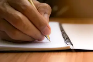photo of person writing in journal