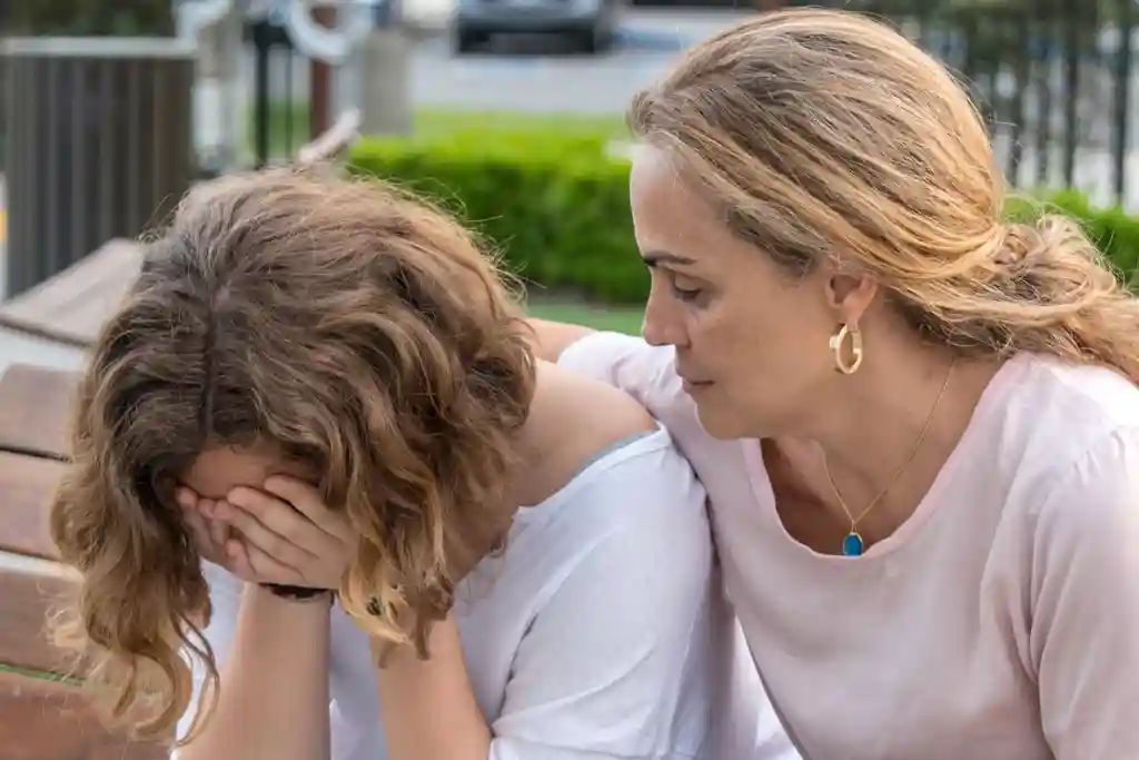 woman comforting crying female child
