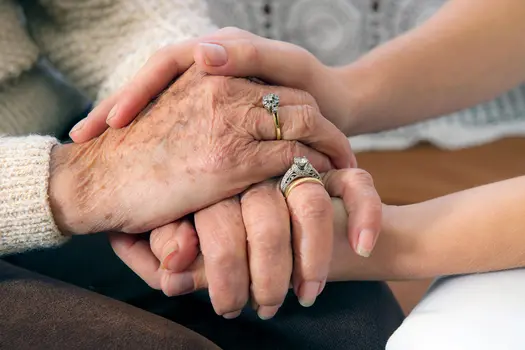 photo of woman holding hands with senior woman