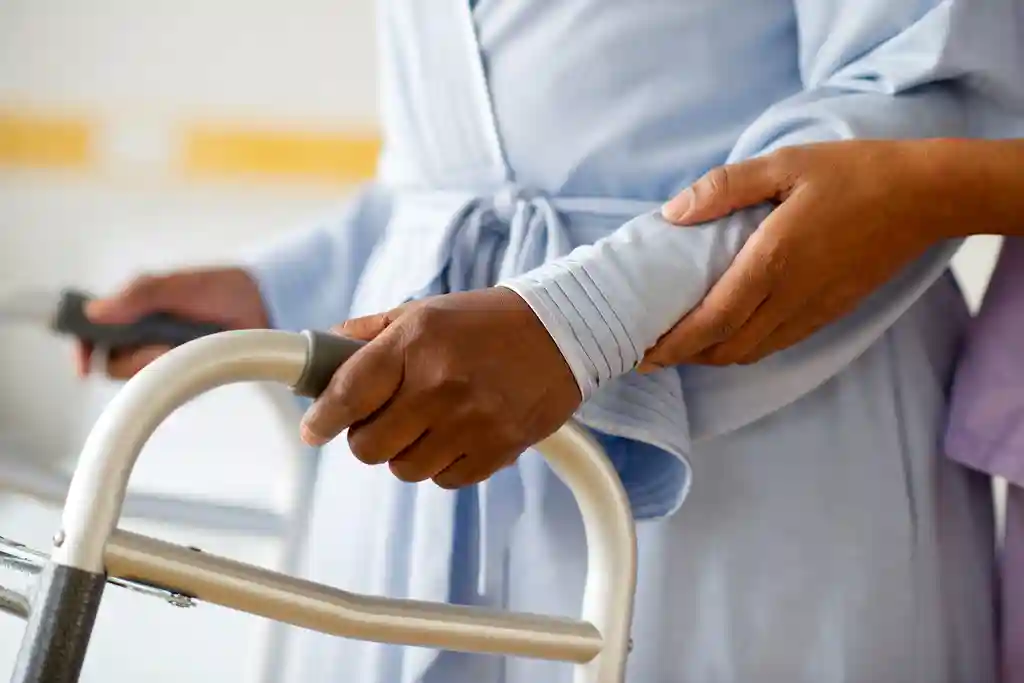 photo of nurse helping patient use walker