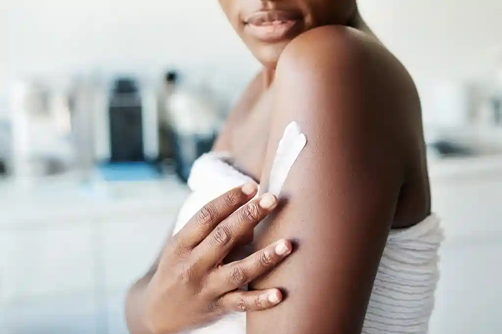 photo of woman applying moisturizer
