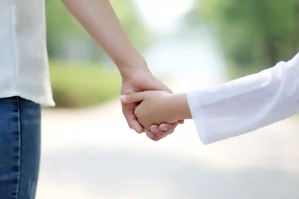 photo of mother holding hands with daughter